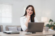 © PRIME STOCK LAB - Confident Asian Businesswoman in White Shirt Working on Laptop at Modern Home Office Desk.