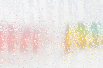 Condensation on glass with colorful blurred background.
