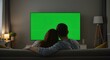 © Golden Bamboo Studio - Couple Watching Tv at Home Relaxing on Sofa - Green Screen