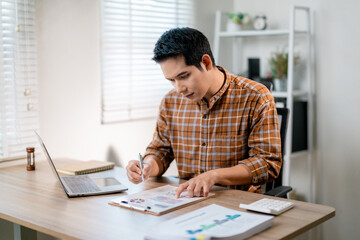 Poster - Young entrepreneur analyzing financial data using laptop and documents working from home office