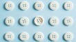 © O - Pattern of white buttons on light blue background with unique offset