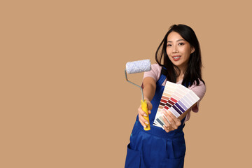 Wall Mural - female asian painter with paint color palettes and roller on brown background