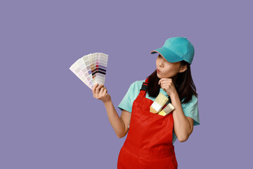 Wall Mural - female asian thoughtful painter with brushes and paint color palettes on purple background