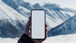© oxart_studio - Hand holding smartphone against snowy mountain landscape, Mockup
