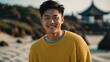 © Alteisen Riese - Good-looking young asian guy in yellow themed sweater on a beach smiling