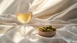 © budiyono - White wine, olives, sunlight, fabric background;  food & drink imagery