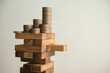 © pla2na - Stack coins on danger wood tower block game with white wall background copy space. Concept of business risk management, global economic crisis, financial bank run or bankruptcy, loss in investment.