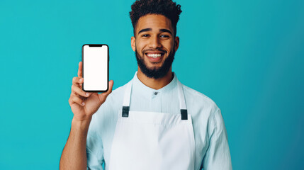 a smiling african chef in a white apron holds a cell phone with an empty screen on a blue background