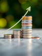 © Annette - Stacked coins and an upward trend line symbolize growing financial success.