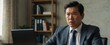 © ULTRA STOCK'S - Angry Asian businessman sits at his desk, looking at his laptop screen with a frustrated expression