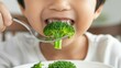 © Z A C - Child eating broccoli from plate.