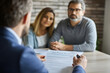 © Vitalii Shkurko - In an office setting, a lawyer clarifies a legal document to a couple, providing guidance and answering questions. The atmosphere is focused and professional, emphasizing clear communication
