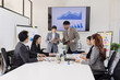 © SOMKID - Group of business people working together with dashboard analysis and data management a meeting table in an office.