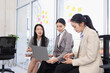 © SOMKID - Three Asian businesswoman talking together with laptop and brainstorm sitting in modern office, Business startup and company strategy planning concept.