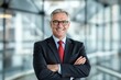 © Pixels Hunter - Confident senior businessman in suit with arms crossed.