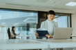 © BGStock72 - Professional Asian woman engaged in work at modern office during a busy afternoon