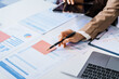 © Phushutter - Two female business professionals in suits sit at desk, engaged in strategic discussion. They analyze financial planning, risk management, corporate growth while reviewing reports and market trends.