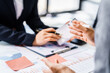 © Phushutter - Two female business professionals in suits sit at desk, engaged in strategic discussion. They analyze financial planning, risk management, corporate growth while reviewing reports and market trends.