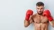 © khonkangrua - Confident Male Boxer in Red Gloves Preparing for Match Against Light Background