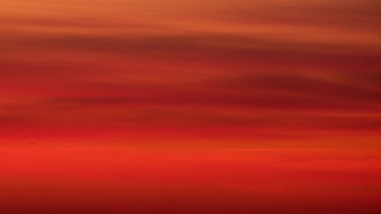 Wall Mural - Blurred sunset sky with red and orange gradient clouds, time lapse. Abstract nature background. Natural atmospheric backdrop for design and print