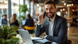 © Stella - Smiling businessman talking on phone while working in a cafe