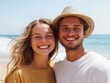 © sponge_Po - Young couple smiling together on a sunny beach with ocean waves in the background