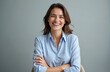 © Vadym - Studio portrait of attractive laughing woman. Brunette smiling with toothy smile in blue striped shirt sitting with arms crossed against grey background. Positive emotion, confident pro look.