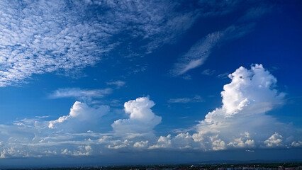 Wall Mural - Majestic Cumulus Clouds Against a Deep Blue Sky Over a Scenic Landscape
