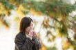 © Yoshida - Winter at Ohori Park in Chuo Ward, Fukuoka City, Japan. A 29-year-old Japanese woman wearing a checkered coat. She sits on a chair by the pond, eating sweets.