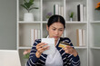 © Natee Meepian - Concerned woman checking credit card details while managing finances.