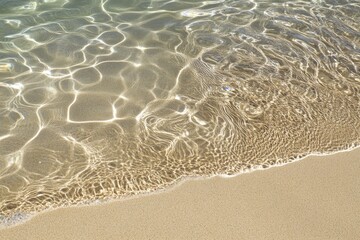 Wall Mural - crystal clear water and soft sand on a sunny beach shoreline