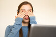 © Соня Монштейн - Overworked woman rubbing eyes due to dryness fatigue feeling headache having eyesight problems after computer work. Prolonged screen time digital eye strain sensitivity to light digital addiction.
