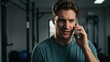 © Qbertstudio - Caucasian man in sportswear talking seriously on phone in modern gym Themes include fitness, motivation, and personal training