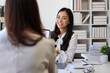 © Kainnika - Female employee is talking with a colleague in the office. Asian woman doing job interview in office.