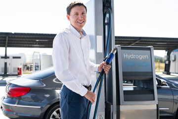 Aufkleber - Man holds a hydrogen fueling nozzle on a hydrogen filling station. Refueling car with hydrogen fuel