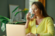 © dragonstock - Freelancer young woman working at home and drinking water