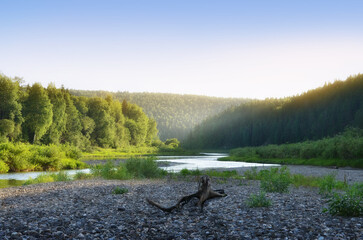Wall Mural - a natural landscape with a river flowing into the distance and the rays of the sun shining through a