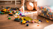 © Victoria - Little girl cleans up her touys in messy room on a floor. Children chores concept.