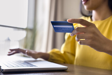 Close up view woman engaged in online transaction or purchases using laptop, enter debit card details for payment, make order or internet shopping, pay bills, booking services use secure e-bank system