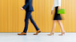 © Nakarin - Blurred figures walking in modern business environment with yellow striped wall