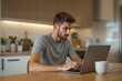© PlanetOfVectors - Young man in casual attire working on laptop at wooden table with coffee mug, modern kitchen background. Concept of remote work, creativity. Ai generative