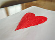 © RooM The Agency - Close-up of a child's drawing of a red heart on a wooden table