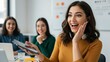 © Qbertstudio - Young Latina woman in earphones holds tablet, smiling with colleagues in office Themes of collaboration and diversity