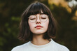 © Anton Moskovchenko - Peaceful woman with glasses, short hair resting outdoors, eyes closed, experiencing tranquil moment amid green landscape