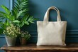 © MdAli - Beige Tote Bag Mockup Eco-Friendly Canvas Bag on Wooden Table with Plants