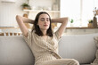 © fizkes - Chilling out. Serene carefree young woman enjoy good free summer day at home relax on sofa in laid back way keep eyes closed dream in light modern kitchen unwind nap feel stress free in calm lazy mood