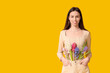 © Pixel-Shot - Happy smiling young woman with hyacinth flowers on yellow background