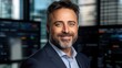 © nattapon - A well-dressed professional with a beard smiles confidently in a modern office setting, showcasing technology and urban views, This image is ideal for business, finance, and corporate promotions,