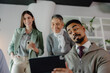 © Jovan - Team Collaborating Enthusiastically Around Tablet in Workplace