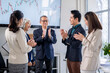 © Wasana - A group of people clapping in a conference room